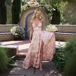 Floral halter maxi dress with high slit and ruffles in a garden setting