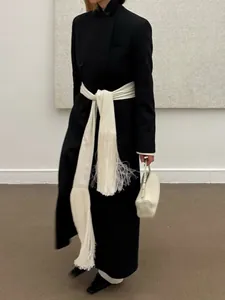 Elegant long white satin wrap belt with decorative fringe tassels on black wool coat