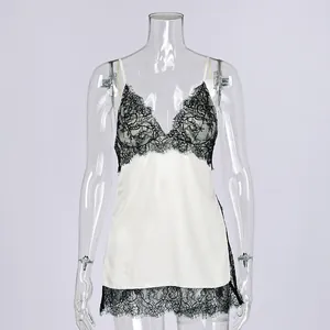 Close-up of elegant white satin camisole with exquisite black floral lace trim.