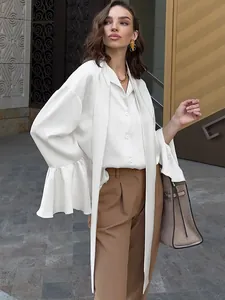 Detail of elegant white satin blouse featuring a tie-neck and flounce bell sleeves.