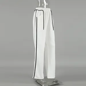 Détail latéral du pantalon de jogging blanc avec cordon et rayures noires contrastées
