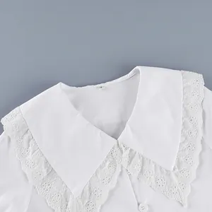 Detailed macro shot of white French cotton blouse with elegant lace Peter Pan collar
