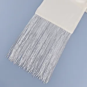 Close-up detail of premium white satin waist belt featuring long elegant fringe tassels