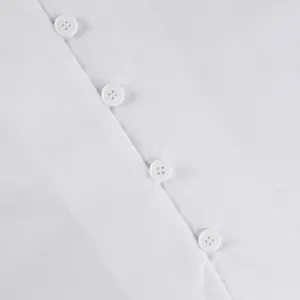 Macro view of elegant white buttons on a minimalist pure cotton French shirt detail.