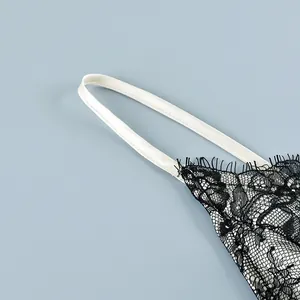 Close-up of black floral lace camisole with thin white strap and eyelash fringe trim