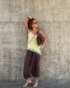Detailansicht eines stylischen asymmetrischen Spitzen-Camisoles mit brauner Hose