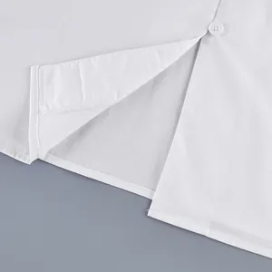 Close-up detail of the hem and button on a minimalist white French style cotton shirt