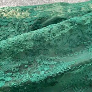 Gros plan sur une robe française verte avec une broderie complexe en dentelle florale