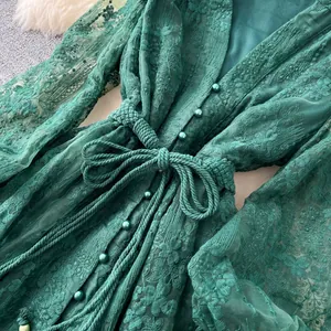 Gros plan sur la robe verte de style français avec broderie et ceinture tressée.