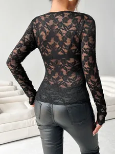 Vue arrière d'un élégant haut en dentelle noire à manches longues et motifs floraux.