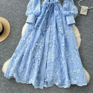 Vue détaillée des broderies florales complexes sur une robe longue bleu clair de style français