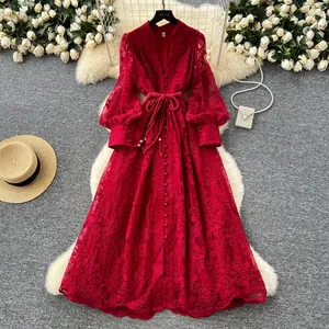 Robe en dentelle brodée rouge de style français présentée à plat avec accessoires élégants.