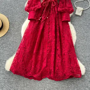 Vue détaillée d'une robe française rouge avec broderies lourdes et manches lanternes élégantes.