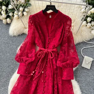 Robe rouge brodée élégante avec col en V et manches lanternes en présentation.