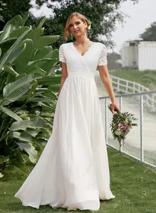 Full-length view of a white lace and chiffon V-neck wedding dress in a garden