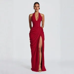 Elegant red halter neck evening gown with high slit and draped detailing.