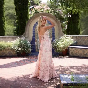 Back view of elegant floral print maxi dress with lace-up detail in a garden setting