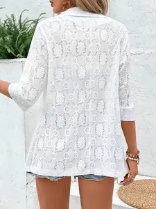 Detailed back view of an elegant white lace blazer with intricate floral hollow-out design