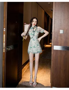 Full length view of a modern green floral lace Qipao dress on an Asian model in a hotel corridor