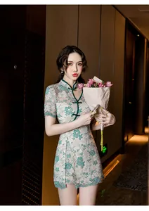 Detail showing the delicate green lace embroidery on a modern cream-colored Qipao dress