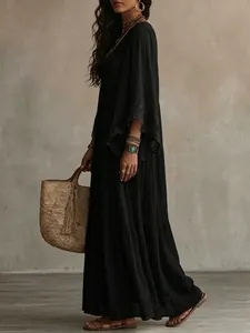 Side view of black bohemian long dress with lace patchwork and batwing sleeves