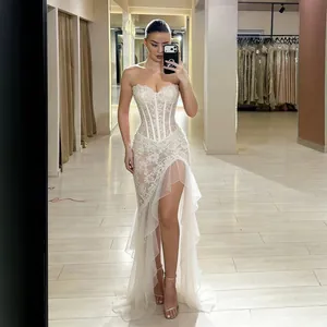 Exquisite detail of white lace strapless evening gown with high slit and tiered ruffles