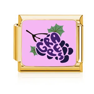 Dettaglio macro di un charm italiano in acciaio dorato con design di uva viola rosa