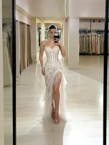 Elegant white strapless lace evening gown with ruffled slit and mermaid silhouette