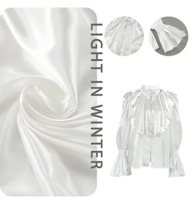 Macro detail of elegant white satin blouse with ruffled collar and glossy fabric texture