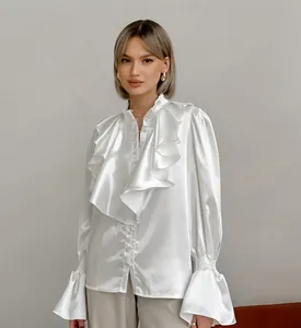 Detailed view of the shiny satin fabric and ruffle layers on the white court-style blouse