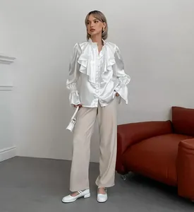 Elegant French ruffled satin blouse with stand collar and flare sleeves in white.