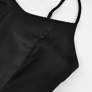 Detailed macro view showing the fine stitching and satin fabric of this black camisole top