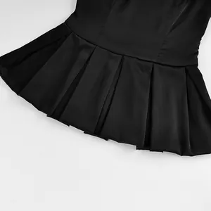 Detail view of black pleated peplum hem on an elegant solid color camisole vest