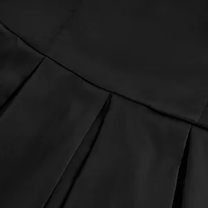 Macro view showing the fine pleated details and fabric texture of a black A-line top