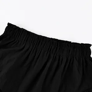 Close-up detail view of black high waist ruffled elastic waistband on tiered fashion skirt