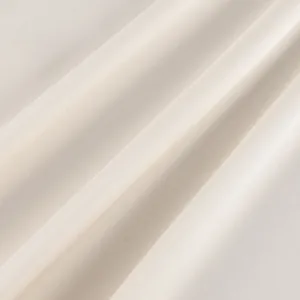 Detailed macro view of ivory satin fabric texture showing elegant folds and sheen