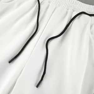 Gros plan d'un pantalon blanc décontracté avec un cordon de serrage noir ajustable