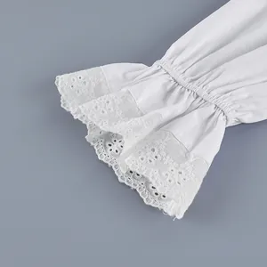 Close-up of white cotton French shirt sleeve with delicate floral lace flare cuff.