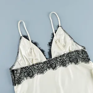 Close-up of elegant cream satin camisole with delicate black lace trim details