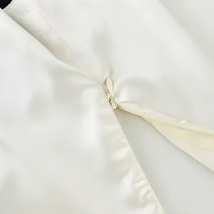 Macro view showing the high-quality invisible zipper on a white chic camisole top