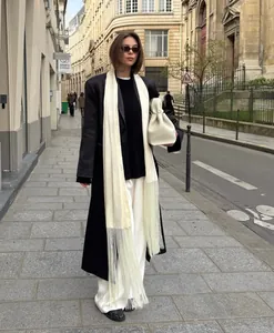 Elegant white satin scarf featuring extra long fringes styled on a European street scene