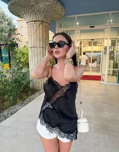 Asymmetrisches Camisole mit Spitzenbesatz in einer stilvollen Outdoor-Umgebung.