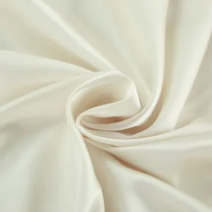 Macro detail of high-quality cream satin fabric showing smooth texture and soft luster
