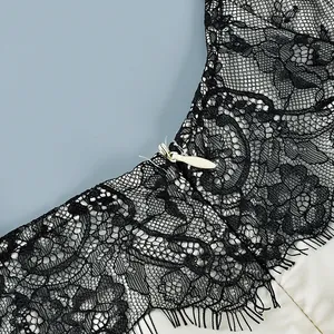 Detailed macro view of black floral lace camisole with ivory lining and zipper