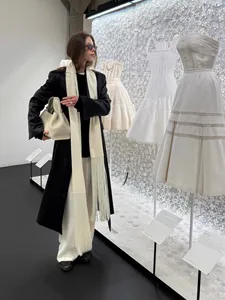 Elegant cream white satin waist sash featuring long decorative fringes shown on black coat