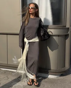 Close-up of a white satin tassel belt styled on a gray dress