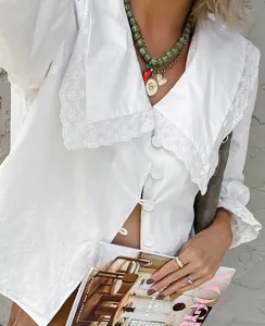 Detail view of a white cotton French shirt with an elegant lace embroidered collar.