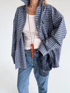 Detail view of a stylish women's vintage blue plaid oversized cotton shirt styled with jeans