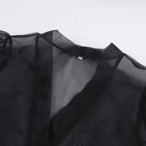 Dettaglio dello scollo a V di una camicia nera sexy in rete trasparente da donna.
