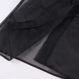 Dettaglio ravvicinato di camicia in mesh nero trasparente con trama del tessuto e orlo